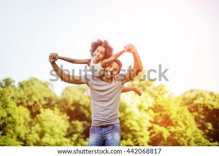 Father carrying daughter piggyback and being truly happy