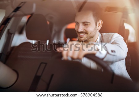 Handsome businessman driving car before buying