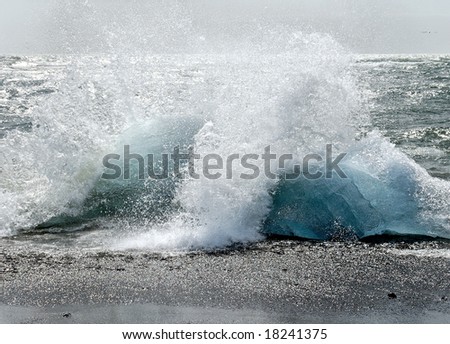 splashing waves on blue-green segments of glacier ice