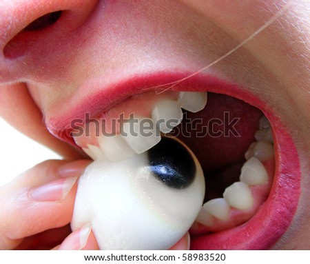 Woman eating candy like an eye - close up