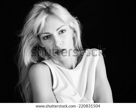 Fashion model with blonde hair on black background. Black and white version.