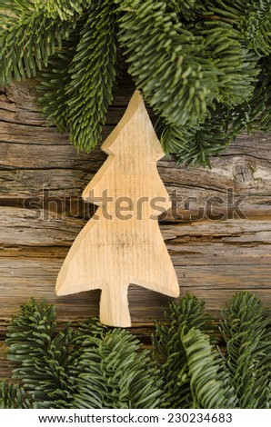 Christmas tree made of wood on wooden background with fir branches