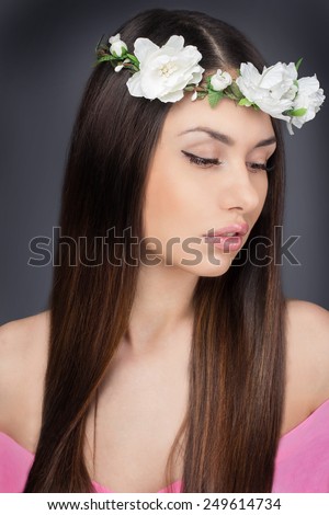 Beautiful woman with long healthy hair and perfect clean skin studio portrait. Beauty face of the young beautiful woman with white flowers in her hair.