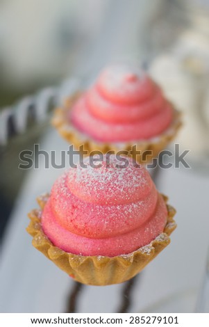 Small cakes with different stuffing. Many tiny cakes with strawberry, whipped cream, jelly and mint