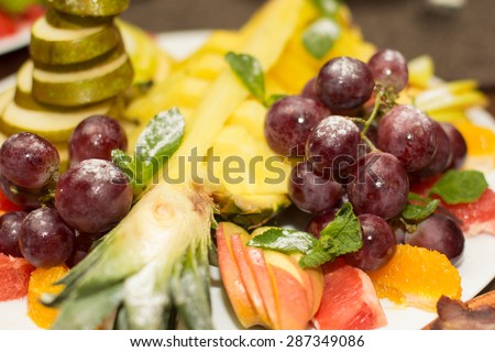 Mixed fruit platter. Variety of fruit on a plate includes grapes, pear, melon, raspberry, mango, pineapple, grapefrut, tropical, juicy, fresh, healthy