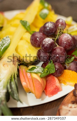 Mixed fruit platter. Variety of fruit on a plate includes grapes, pear, melon, raspberry, mango, pineapple, grapefrut, tropical, juicy, fresh, healthy