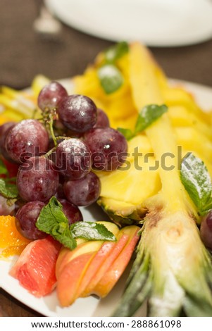 Mixed fruit platter. Variety of fruit on a plate includes grapes, pear, melon, raspberry, mango, pineapple, grapefruit, tropical, juicy, fresh, healthy