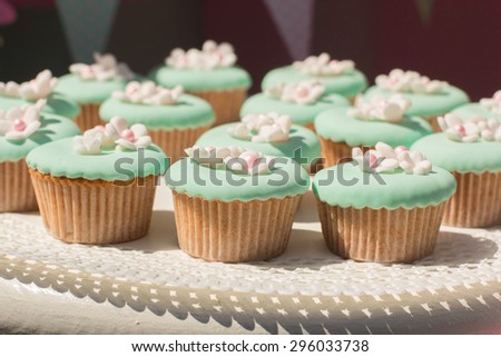 Small cakes with different stuffing. Many tiny cakes, whipped cream, jelly and mint
