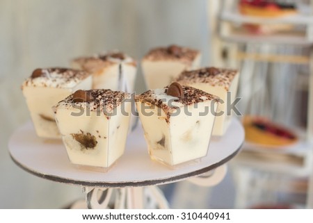 Small cakes with different stuffing. Many tiny cakes with strawberry, coffee, whipped cream, jelly and mint