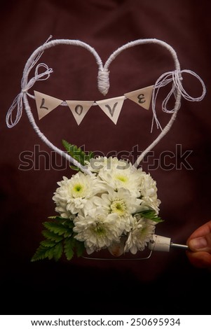hend hold decoration  from white flowers and words LOVE