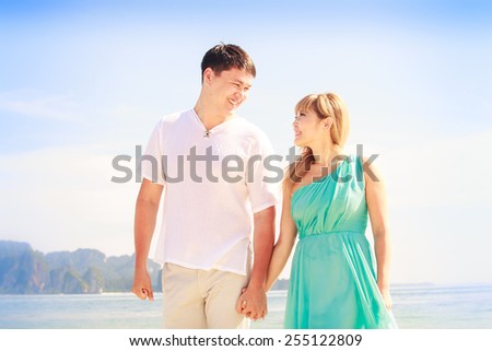 young handsome man walk with beautiful blonde girlfriend in blue dress