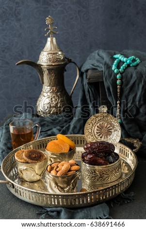 Ramadan kareem with premium dates,nuts and Arabic tea. Festive still life of iftar food concept.