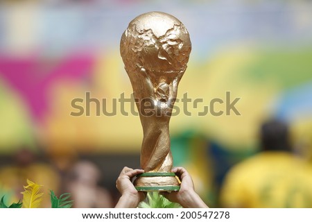 BRASILIA, BRAZIL - JUNE 23, 2014: A fan showing a fake World Cup Trophy during the World Cup Group A game between Cameroon and Brazil in the National Stadium. NO USE IN BRAZIL.