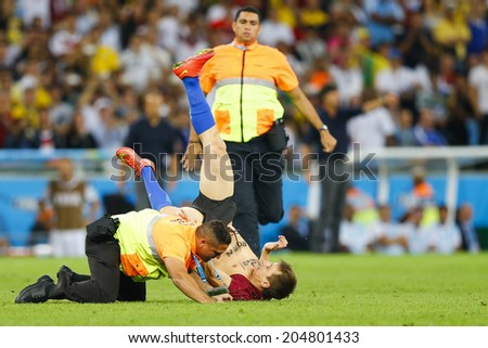 RIO DE JANEIRO, BRAZIL - July 13, 2014: Security personnels catch a pitch invader during the 2014 World Cup Final game between Argentina and Germany at Maracana Stadium. NO USE IN BRAZIL.