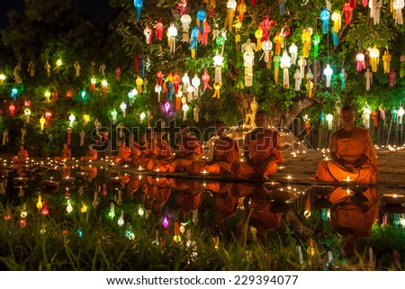 CHIANG MAI, THAILAND - NOVEMBER 06, 2014: Loy Krathong ceremony: Buddhist monks meditating in front of the Buddha image in Phan Tao Temple