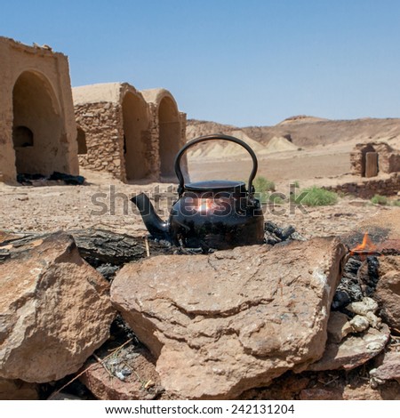 Tea kettle on campfire in iranian desert Dasht-e Kavir near abandoned village