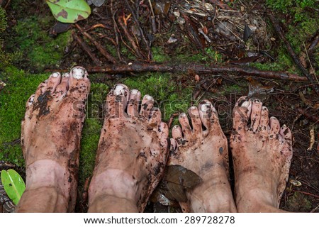 Dirty feet on moss in jungle