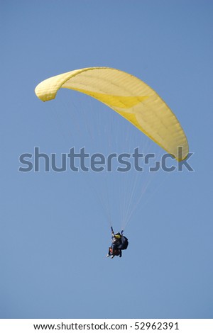 Double Paragliding flying through the sky above the ocean