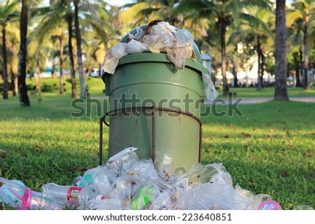 overflowing green garbage bin