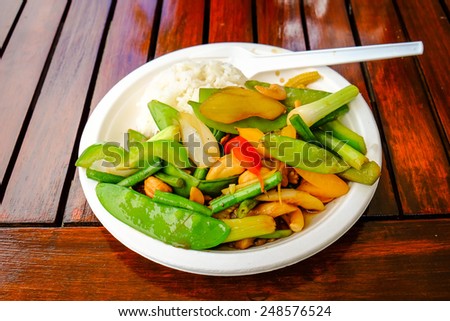 Thai food served on a paper plate outdoors