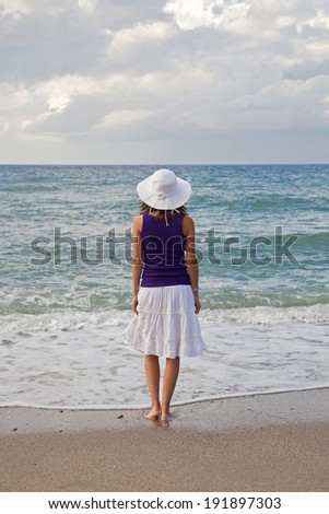 Woman looking at the sea before sunset. Summer concept.