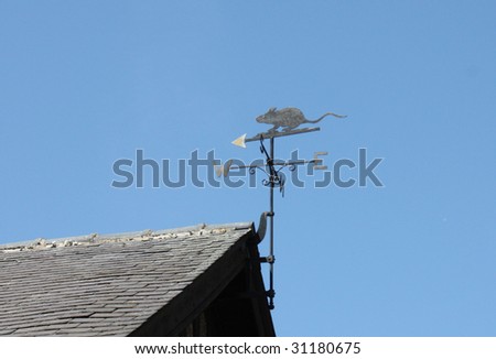 A Metal Wind Vane on the Roof of a Building.