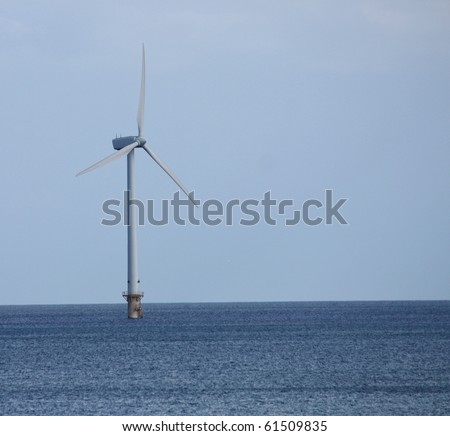 A Single Wind Turbine Tower Standing in the Sea.
