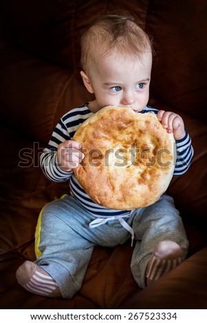 Cute baby boy chewing unleavened wheat cake (lavash)
