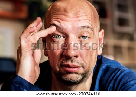 Man is elevating his eyebrow with his hand as he is very sleepy or surprised