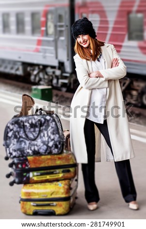 Elegant lady with shih tzu dog in suitcase on the platform standing near train at Vitebsk railway station in St.-Petersburg, Russia. Image with selective focus