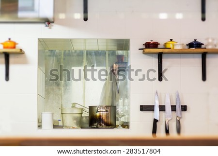 Open kitchen wall with knifes and pans in the restaurant