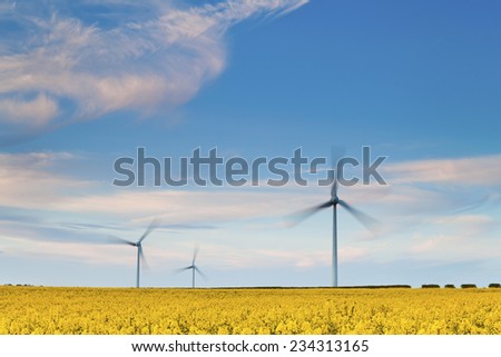 Three Wind Turbines at Yellow Rapeseed Field in Burton Latimer, United Kingdom