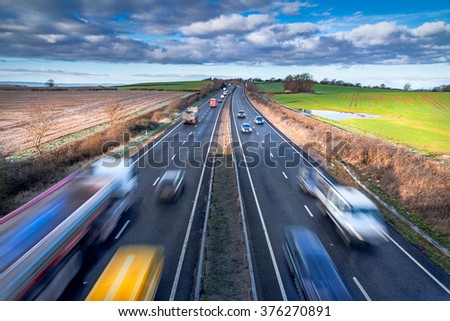 Fast moving Vehicles on Busy Motorway at the Morning
