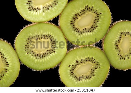Thin slices of kiwi fruit on black background