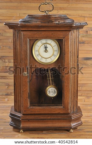 isolated old-fashion wooden clock with pendulum on bamboo background