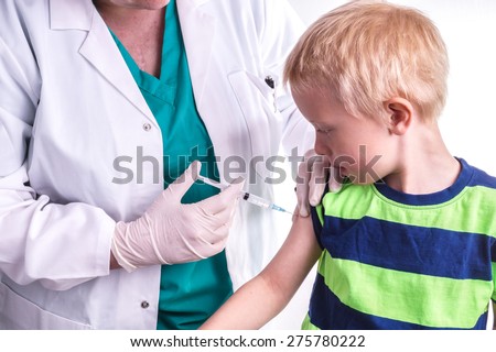 little boy is given an injection by the family doctor. The female doctor gives the child an injection in the upper arm . It can be both a vaccination or as part of the boy\'s medical treatment
