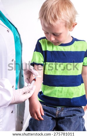 The child has a blood test . The blood sample taken by a lab technician or doctor . The boy is very brave and sit quietly while the sample taken