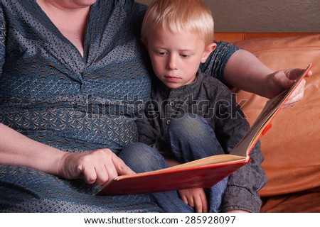 Story time in the couch, Woman reads the book to the little Child