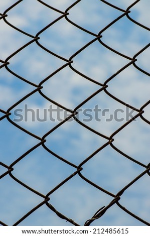 Wire mesh or netting fence against the sky