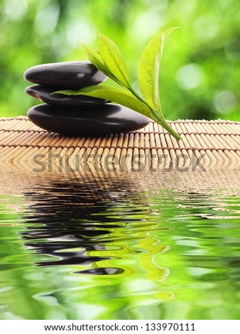 zen stones and water reflection showing spa concept