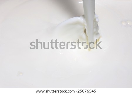 milk splashing into fresh milk with drops