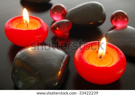 zen harmony with candles and stones on black background