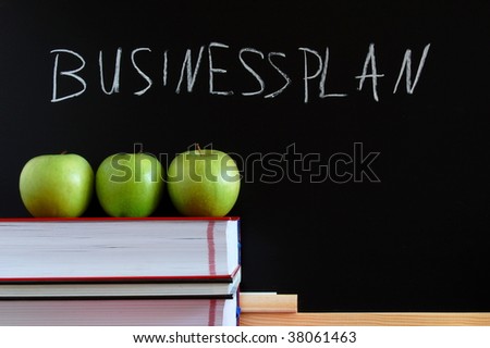 business blackboard with apples and books and space for a message
