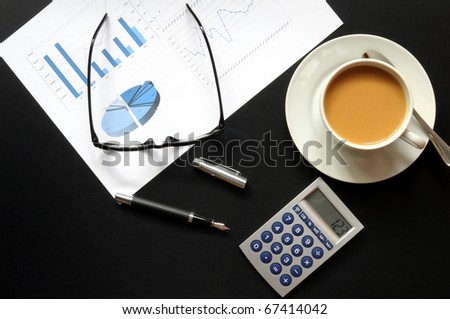 business breakfast in the office on black desktop with calculator pen and glasses