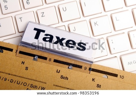 tax or taxes concept with word on business folder index
