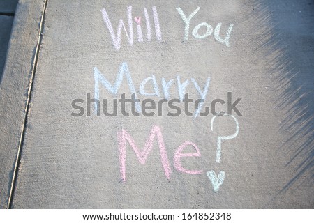 Will you marry me, a message written in chalk on the sidewalk