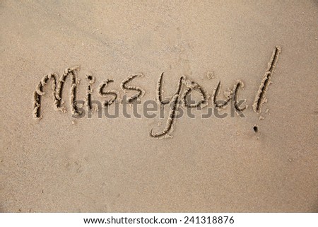 Miss you, a message written in the sand at the beach.