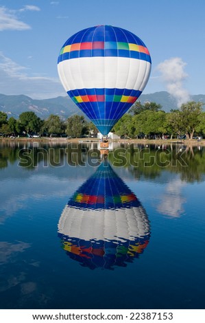 Hot air balloon just over the water\'s surface.