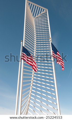 Two American Flags frame in a tall monument.