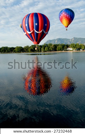 Hot air balloons reflections over water.